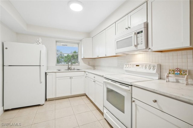 kitchen with white cabinets, white appliances, sink, and light tile patterned floors