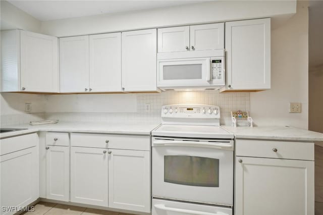 kitchen featuring decorative backsplash, kitchen peninsula, white appliances, white cabinetry, and light tile patterned flooring