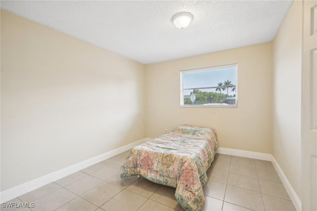 bedroom featuring light tile patterned floors and a textured ceiling