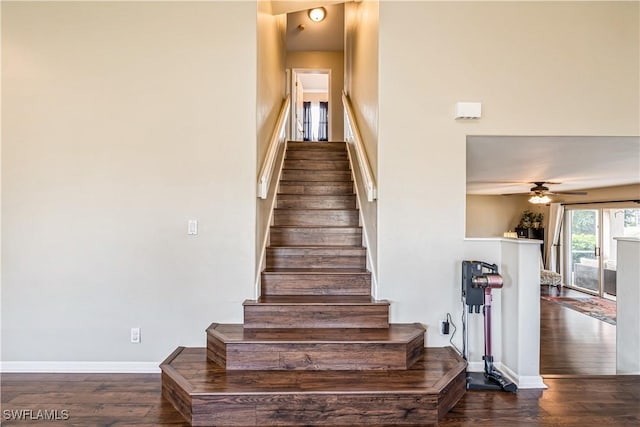 staircase featuring ceiling fan and wood-type flooring