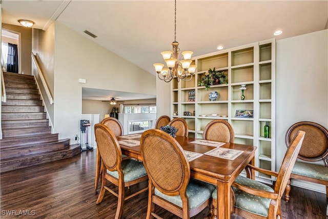 dining area with lofted ceiling, ceiling fan with notable chandelier, and dark hardwood / wood-style floors