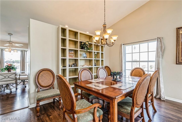 dining area with ceiling fan with notable chandelier, vaulted ceiling, and dark wood-type flooring