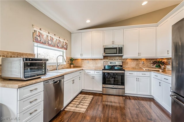 kitchen featuring white cabinetry, sink, lofted ceiling, and appliances with stainless steel finishes