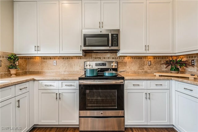 kitchen featuring white cabinets, decorative backsplash, and appliances with stainless steel finishes