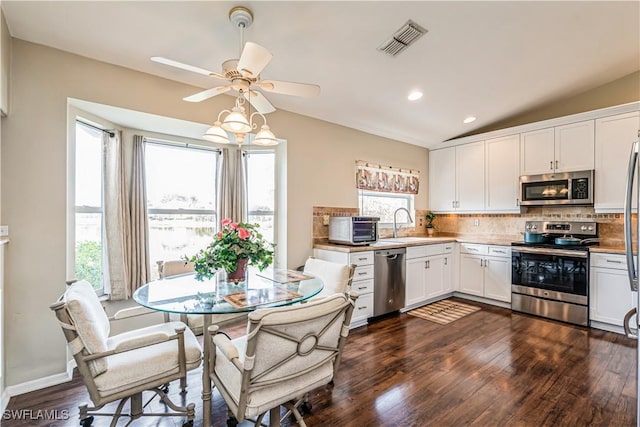 kitchen featuring decorative backsplash, dark hardwood / wood-style floors, white cabinetry, and appliances with stainless steel finishes