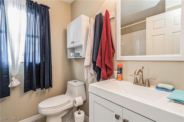 bathroom featuring vanity, toilet, and walk in shower