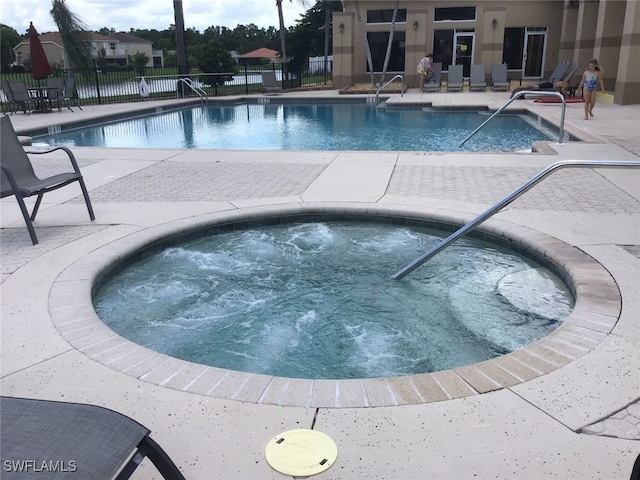 view of swimming pool featuring a community hot tub and a patio