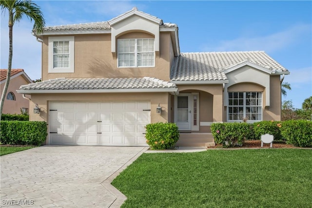 view of front of home featuring a tile roof, a front yard, and stucco siding