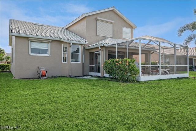 rear view of property with glass enclosure and a yard