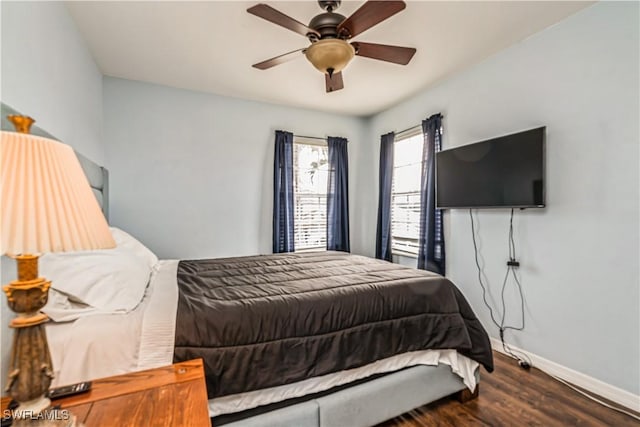 bedroom with dark hardwood / wood-style flooring and ceiling fan