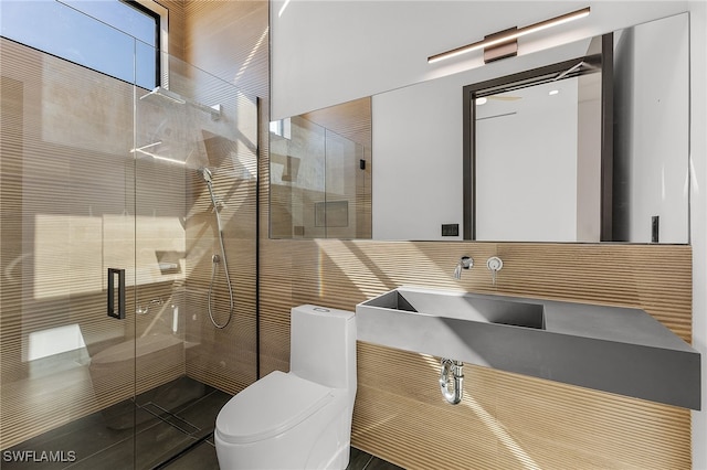 bathroom featuring an enclosed shower, toilet, and sink