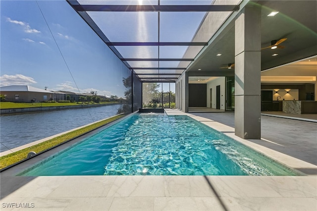 view of pool featuring a patio, a water view, glass enclosure, and ceiling fan