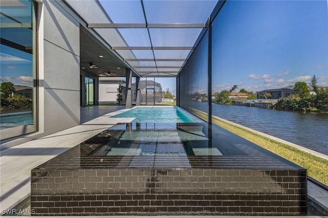 view of swimming pool with an in ground hot tub, a water view, ceiling fan, and a patio area