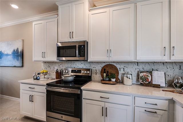 kitchen featuring backsplash, light tile patterned flooring, white cabinetry, and stainless steel appliances