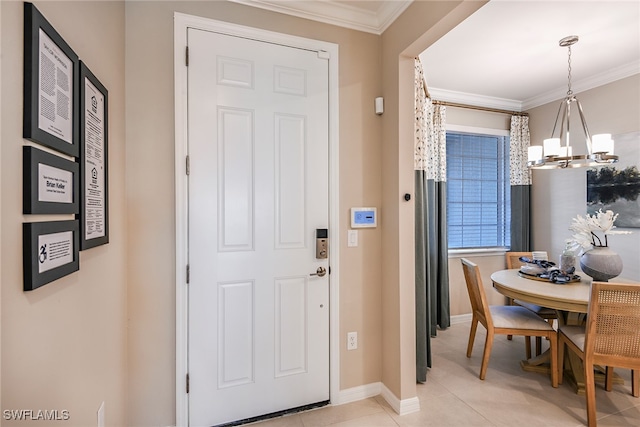 tiled entrance foyer featuring ornamental molding and an inviting chandelier