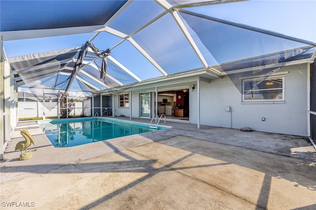 view of pool with glass enclosure and a patio area