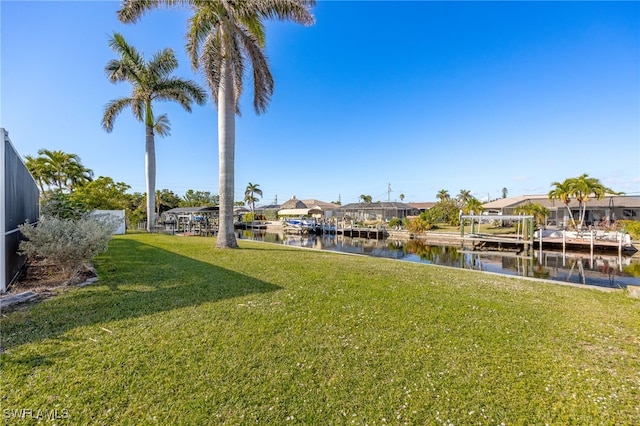 view of yard with a water view and a boat dock