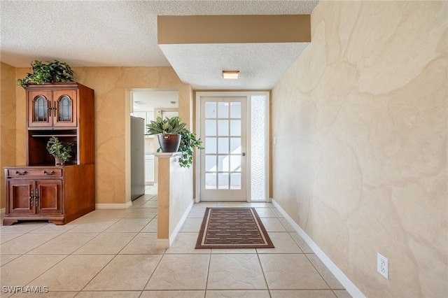 doorway to outside featuring light tile patterned flooring and a textured ceiling