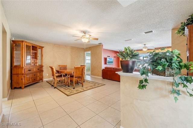 tiled dining room with ceiling fan and a textured ceiling