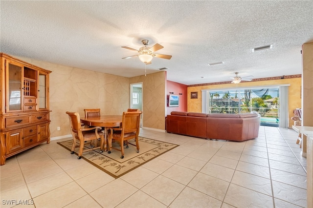 dining area with ceiling fan, light tile patterned flooring, and a textured ceiling