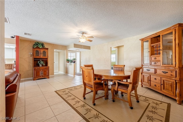 dining room featuring ceiling fan, light tile patterned flooring, and a textured ceiling