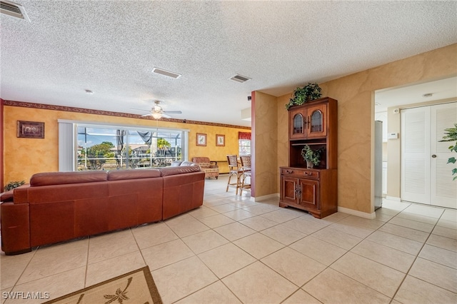 tiled living room featuring ceiling fan and a textured ceiling