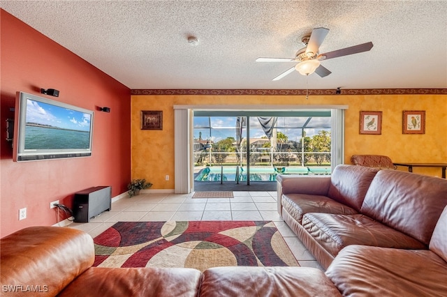 tiled living room featuring ceiling fan, a healthy amount of sunlight, and a textured ceiling