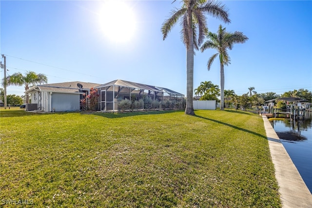 view of yard with a lanai and a water view