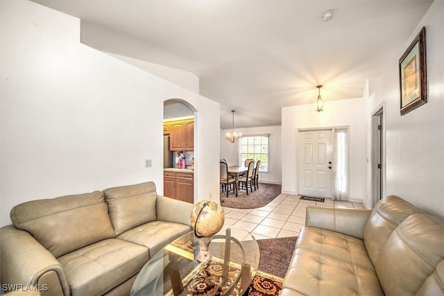 living room featuring light tile patterned floors, lofted ceiling, and a notable chandelier