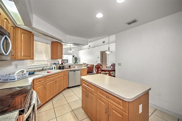 kitchen with hanging light fixtures, ceiling fan, light tile patterned floors, a kitchen island, and stainless steel appliances