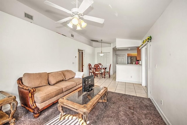 tiled living room featuring ceiling fan and vaulted ceiling