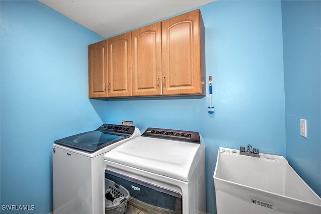 washroom with washer and clothes dryer, cabinets, and sink