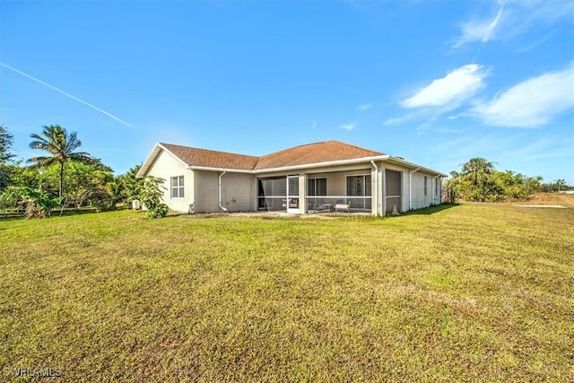 rear view of house with a sunroom and a yard