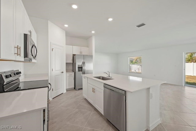 kitchen featuring a wealth of natural light, white cabinets, a kitchen island with sink, and appliances with stainless steel finishes