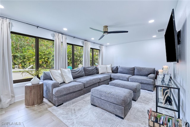 living room featuring ceiling fan, light hardwood / wood-style floors, and a wealth of natural light