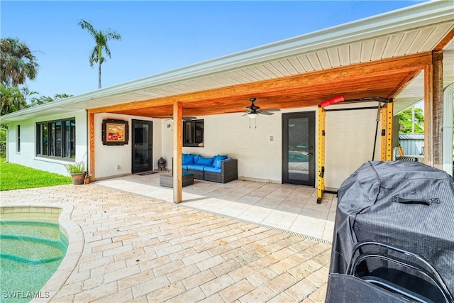 view of patio featuring outdoor lounge area, ceiling fan, area for grilling, and a pool