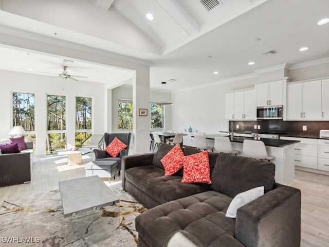 living room with vaulted ceiling with beams, ceiling fan, and light hardwood / wood-style floors