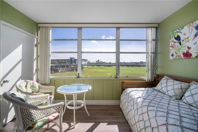 bedroom with hardwood / wood-style flooring and multiple windows