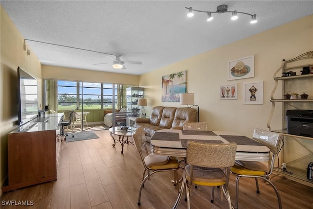 dining room with hardwood / wood-style flooring, ceiling fan, and a textured ceiling