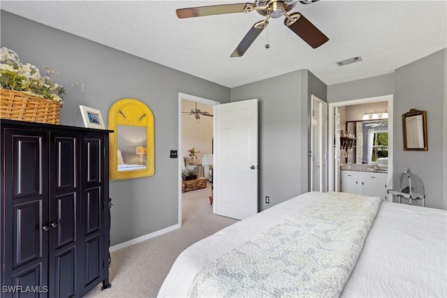 bedroom featuring carpet, visible vents, connected bathroom, a textured ceiling, and baseboards