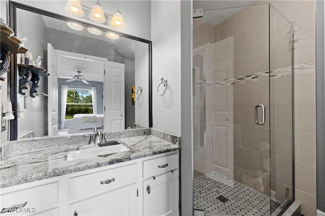 bathroom with ceiling fan, a stall shower, and vanity