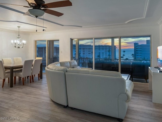 living room featuring ceiling fan with notable chandelier, light hardwood / wood-style flooring, and ornamental molding