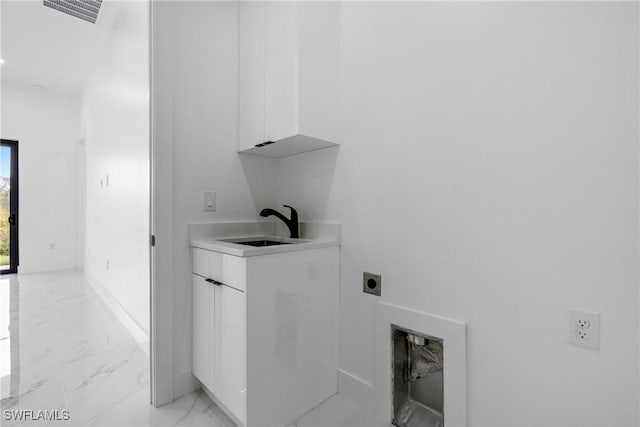 laundry area featuring hookup for an electric dryer, cabinets, and sink