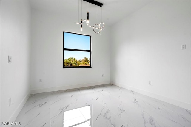 unfurnished room with a notable chandelier