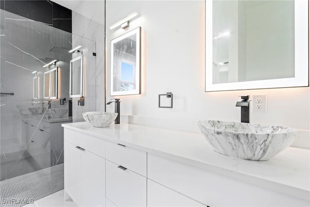 bathroom featuring a tile shower and vanity