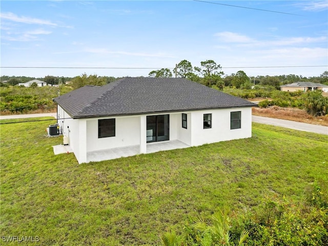 back of house with central AC unit, a patio area, and a lawn