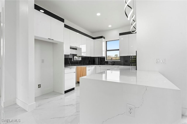 kitchen with dishwasher, backsplash, sink, kitchen peninsula, and white cabinetry