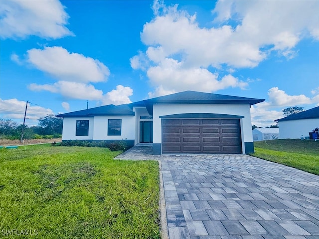 ranch-style home featuring a garage and a front lawn