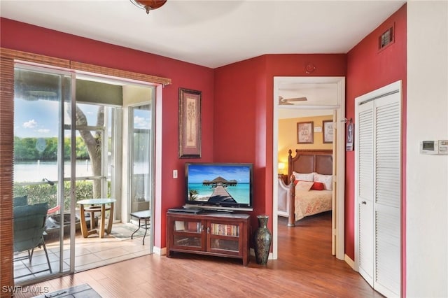 242 Newport Dr Unit 502, Naples, FL 34114 - living room featuring visible vents, baseboards, a water view, wood finished floors, and a ceiling fan