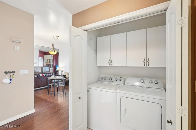 242 Newport Dr Unit 502, Naples, FL 34114 - laundry room featuring washer and dryer, baseboards, cabinet space, and wood finished floors